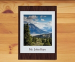 A commemorative card featuring a nature scene with a mountain and trees, alongside a personalized message that includes a tribute to a tree planted in a national forest.