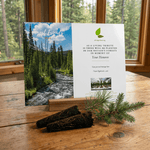 Nature-themed card with a scenic view of trees and a stream on a wooden surface.