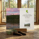 Memorial card with nature scene and text on a wooden surface